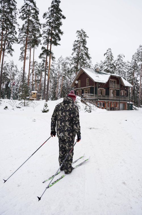 Vīrietis gatavojas sākt slēpot a distanču slēpēm netālu no Latvijas valsts mežu tūrisma un atpūtas centra "Spāre"